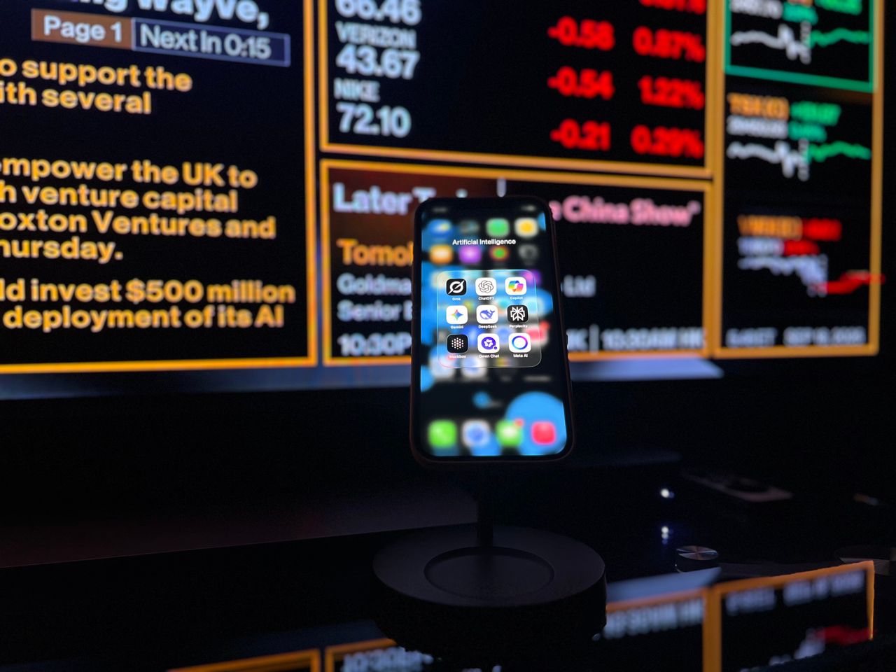 services-04 Smartphone displaying AI apps in front of a financial data screen in London.