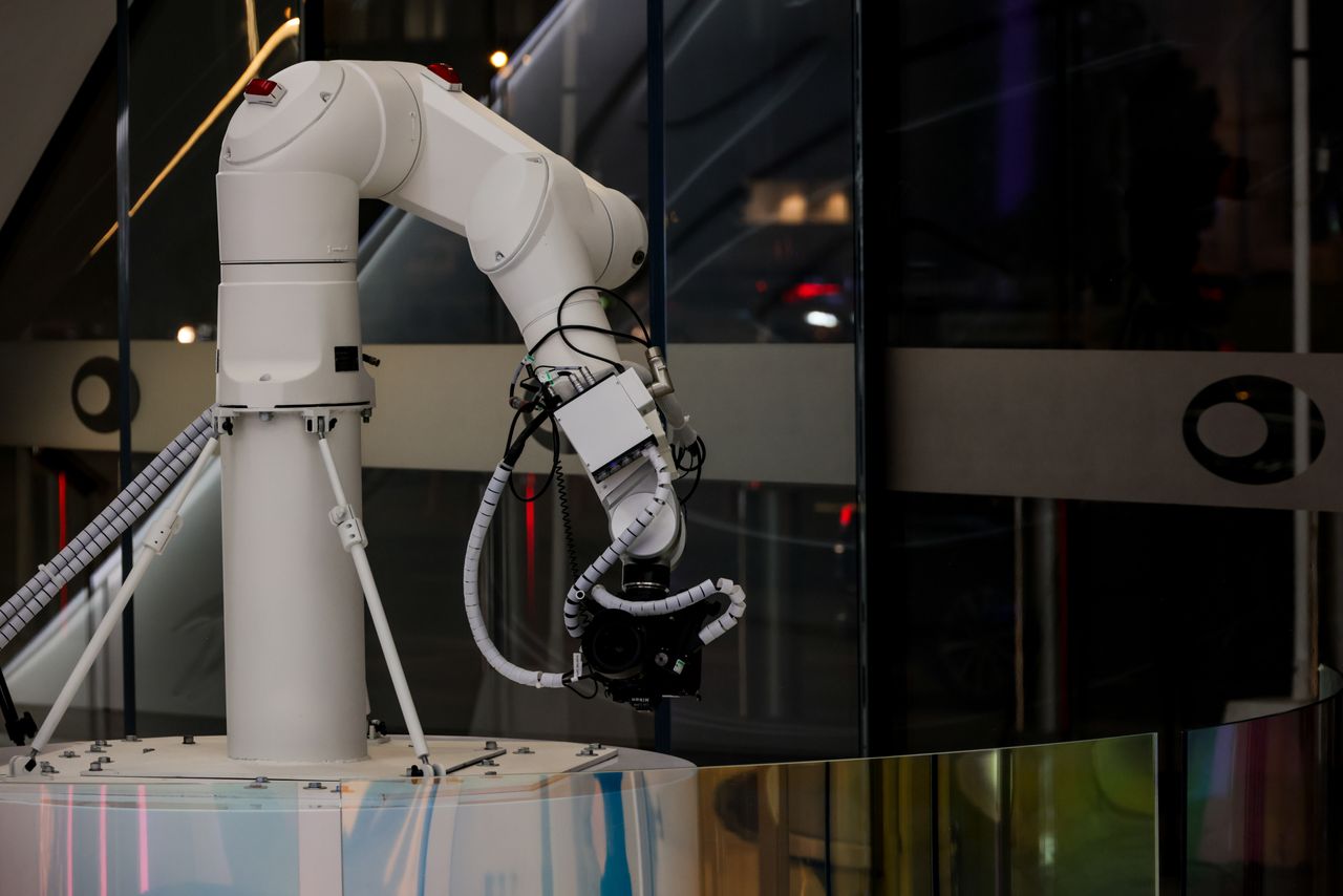 about-us A white robotic arm operating indoors with a modern design and advanced technology.
